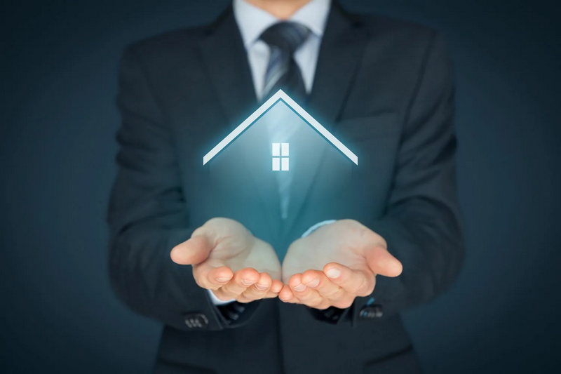 A person in a suit holds their hands out, with a glowing house icon hovering above them.