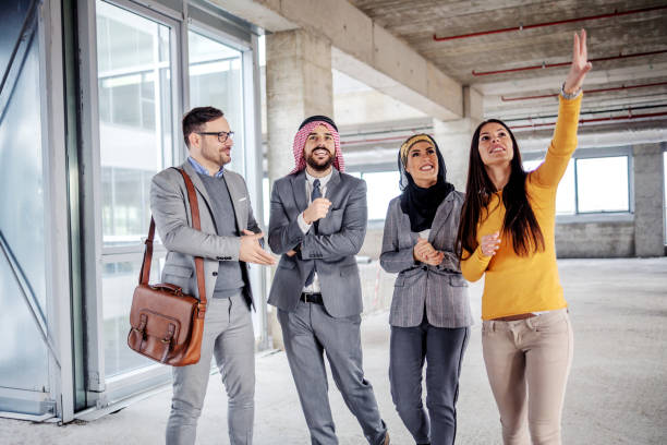 Group of real estate agents discussing property details inside an unfinished building in Dubai.