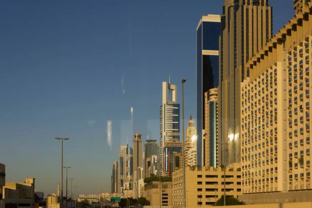 Skyscrapers in Dubai's bustling real estate market glisten in the sunlight against a clear blue sky.