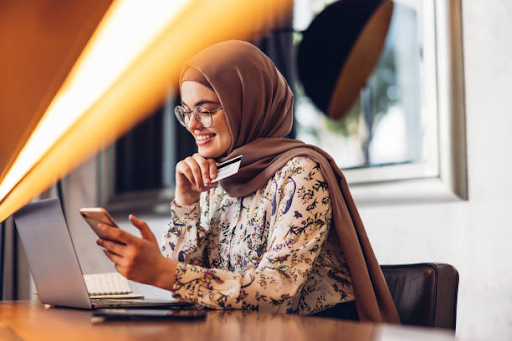 A person in a headscarf analyses data on a computer, potentially reviewing investment details for ELO 3.